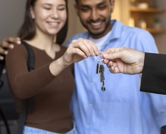 Alt A mortgage lender handing over the key to a house to a happy couple