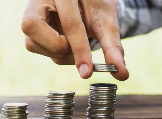 Alt A man stacking coins on top of each other in increasing height