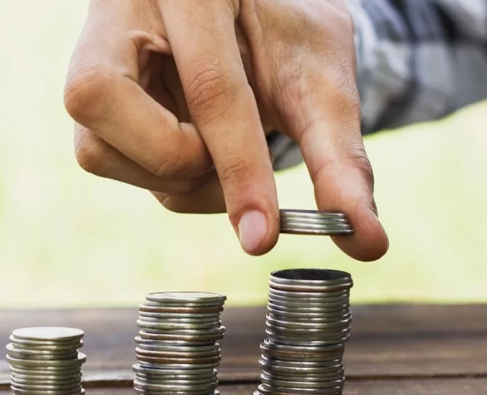 Alt A man stacking coins on top of each other in increasing height