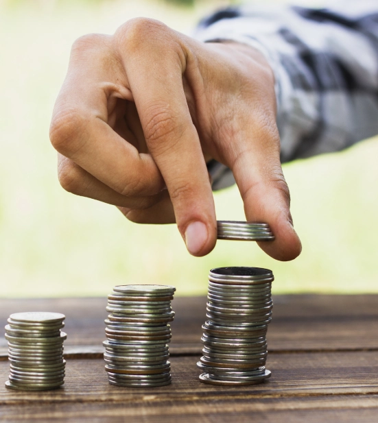 Alt A man stacking coins on top of each other in increasing height