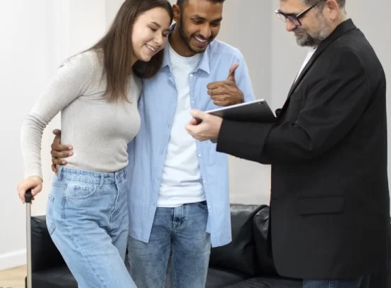 Alt A man and woman moving into a house, with the mortgage lender holding a document.