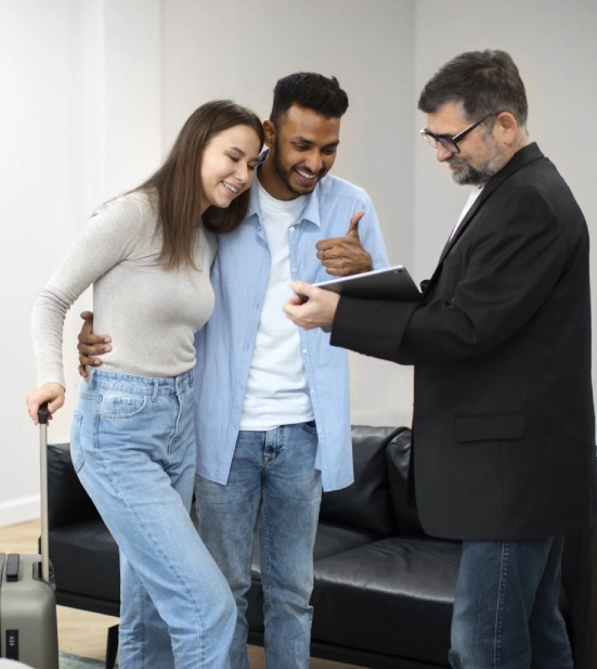 Alt A man and woman moving into a house, with the mortgage lender holding a document.