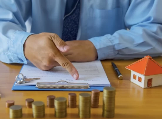 A mortgage lender pointing to a document placed on a clipboard