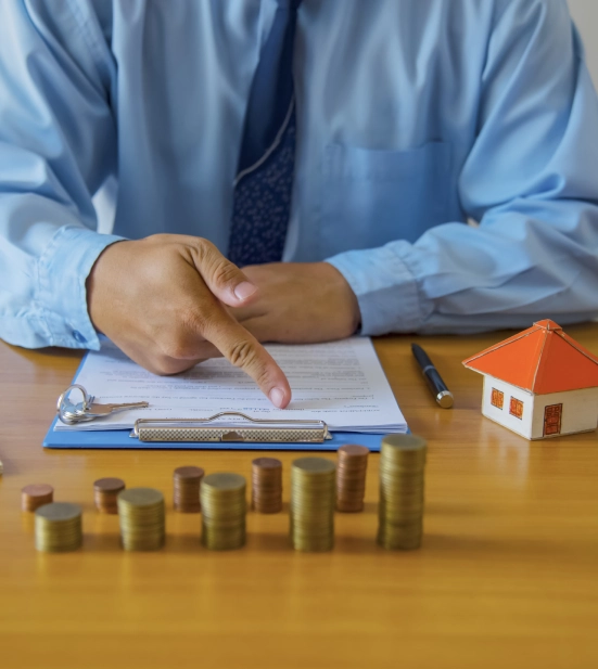 A mortgage lender pointing to a document placed on a clipboard