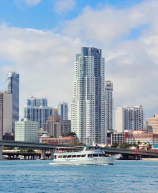 A boat in the Miami Bay with the Vizcayne Luxury Apartments in the background