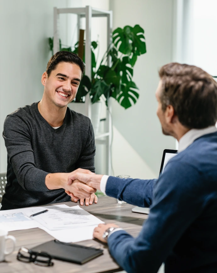 Alt A mortgage lender and a man shaking hands over a table with a few documents